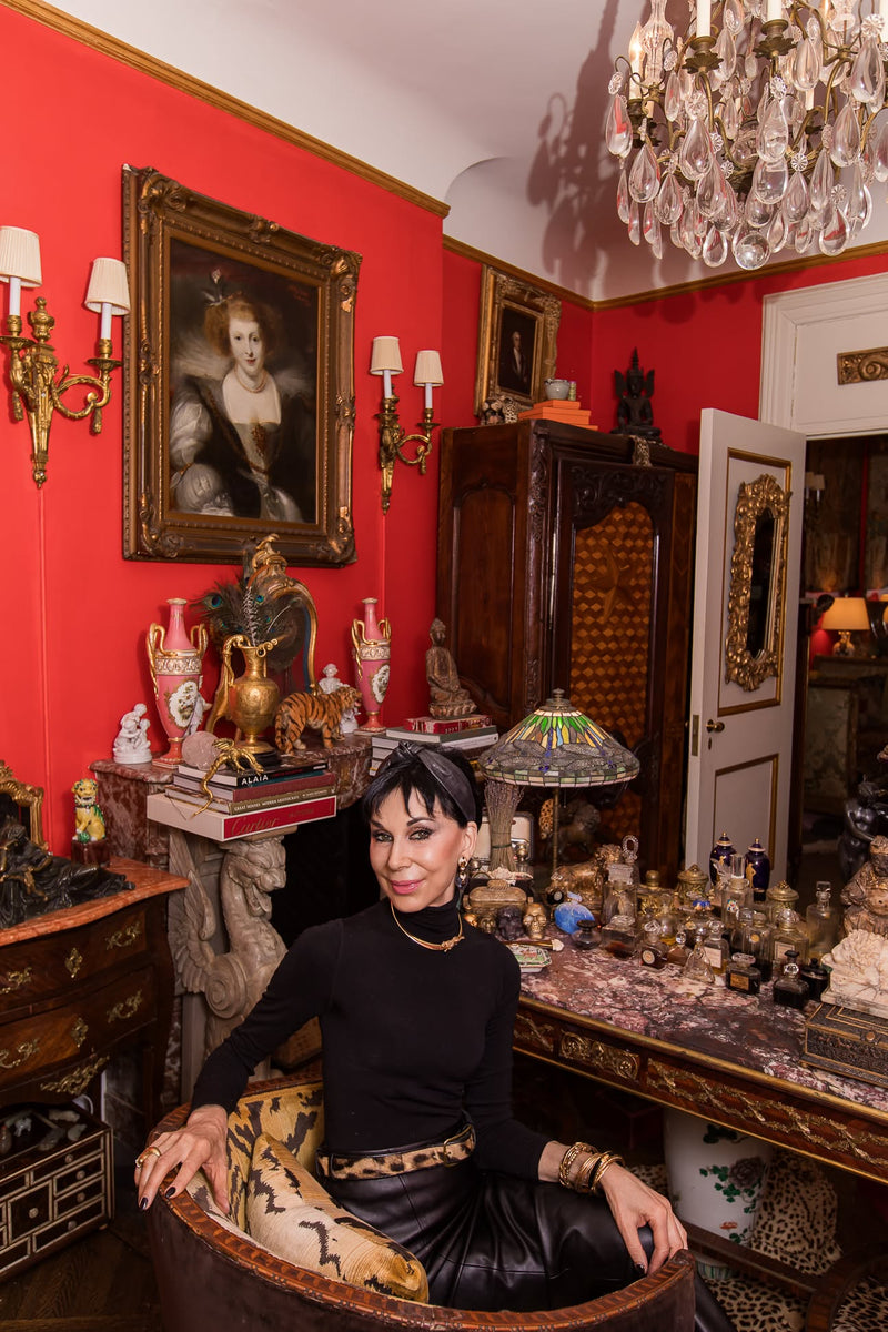 Seated within an 18th-century Italian chair upholstered in Scalamandré Tigre, Cynthia appears  at her   French desk by Millet et Fils where its surface is lined with  Collesta compositions  in old Baccarat flacons from Caron, Houbigant, Guerlain, and